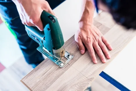 Person sägt Holz mit Stichsäge